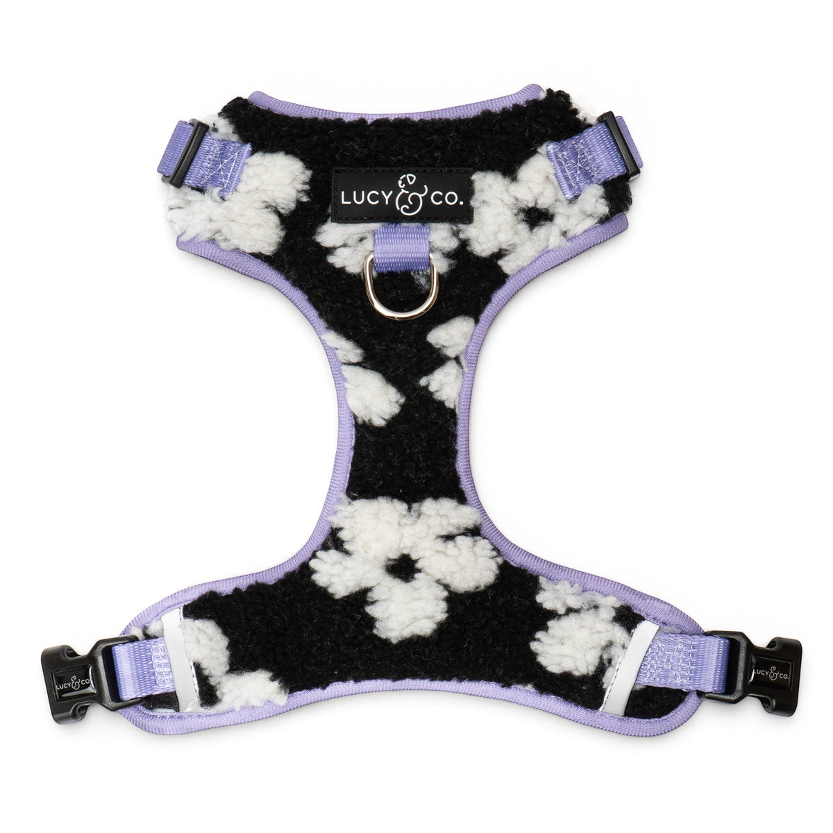 Lucy & Co. Far Out fleece no-pull dog harness in a black and white cow print with lavender trim and metal hardware.