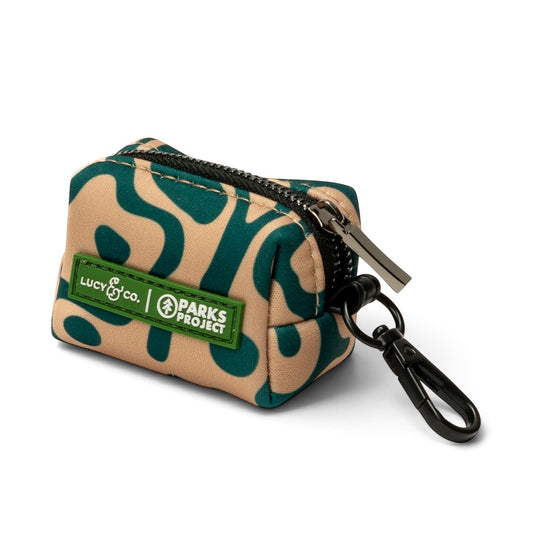 Lucy & Co. x Parks Project Geyser poop bag holder in beige and green neoprene with a black zipper and clip.